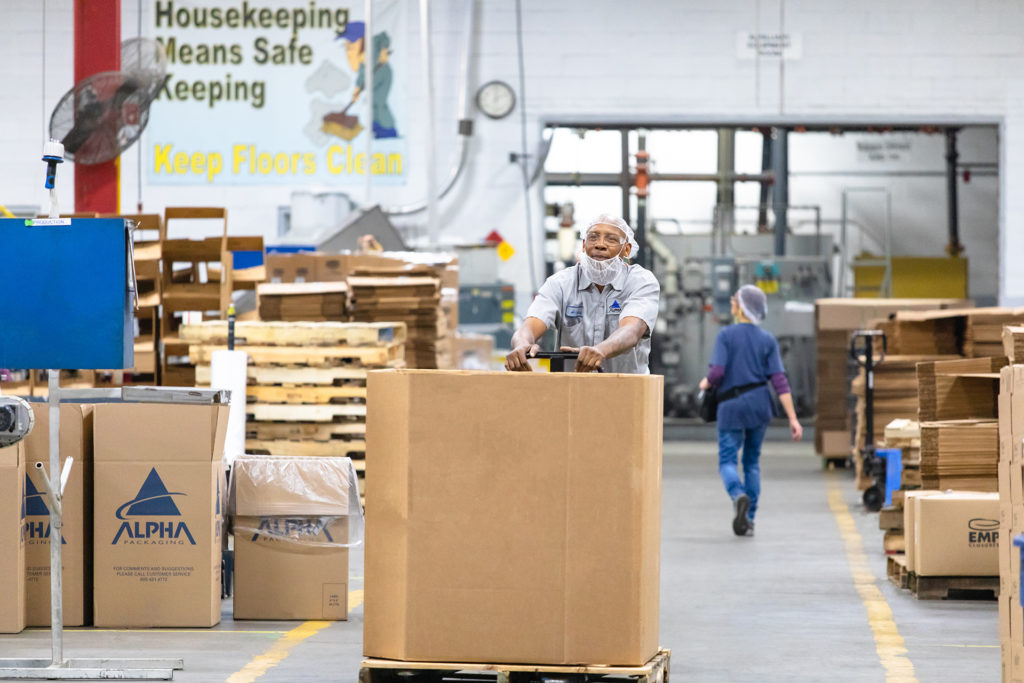 Photo of man pushing box through warehouse